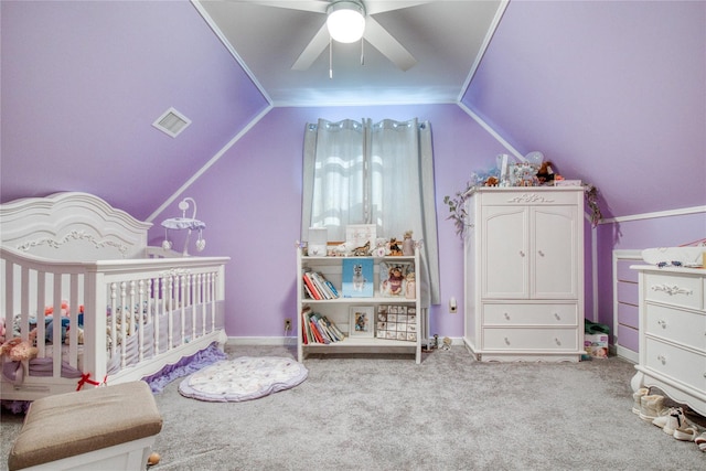 bedroom featuring visible vents, a crib, carpet, and vaulted ceiling