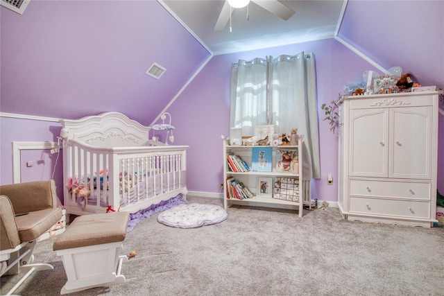 bedroom with a crib, vaulted ceiling, carpet flooring, and visible vents