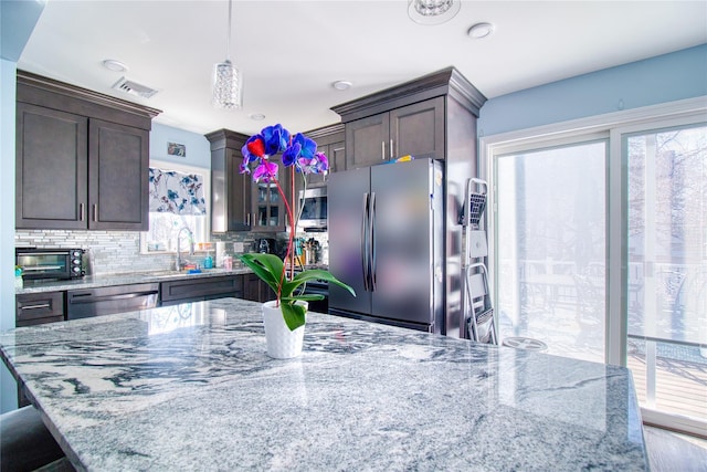 kitchen featuring decorative backsplash, dark brown cabinets, visible vents, and appliances with stainless steel finishes