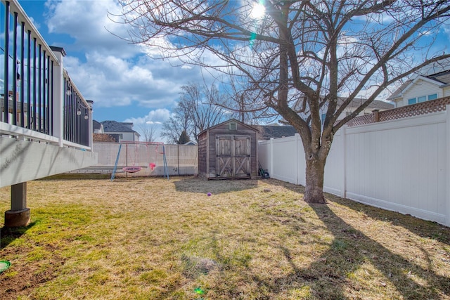 view of yard featuring an outbuilding, a fenced backyard, and a shed