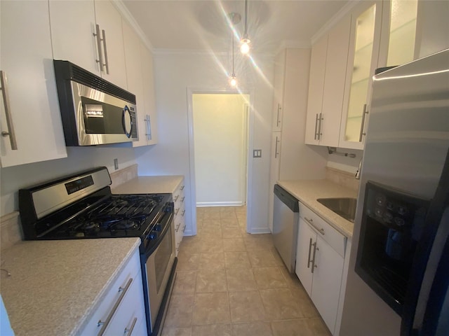 kitchen featuring glass insert cabinets, light countertops, ornamental molding, appliances with stainless steel finishes, and white cabinetry