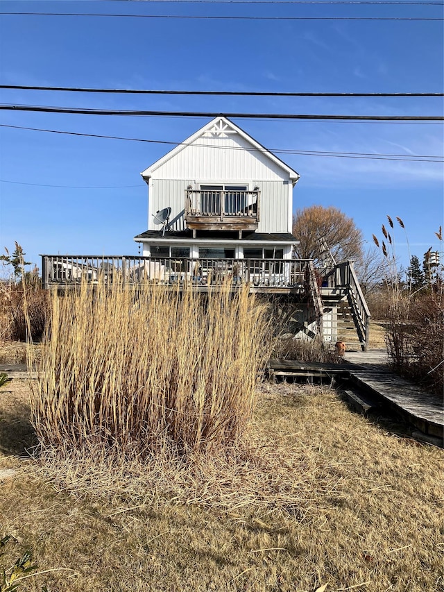 back of house with board and batten siding and stairs