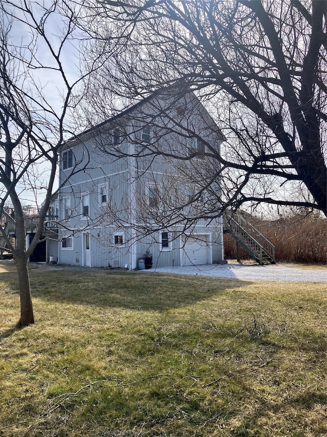 view of home's exterior with a lawn and stairs