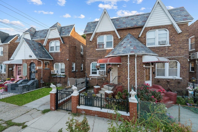 view of front of property with brick siding, cooling unit, a gate, and a fenced front yard