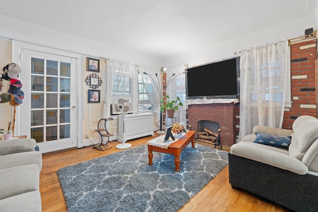 living area featuring a brick fireplace and wood finished floors