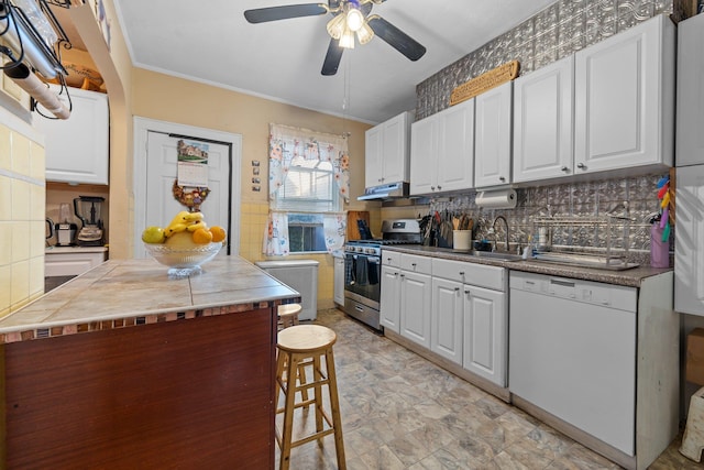 kitchen featuring white cabinetry, under cabinet range hood, stainless steel gas range, a sink, and white dishwasher