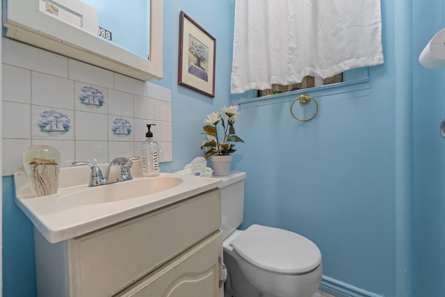 bathroom featuring toilet, decorative backsplash, and vanity