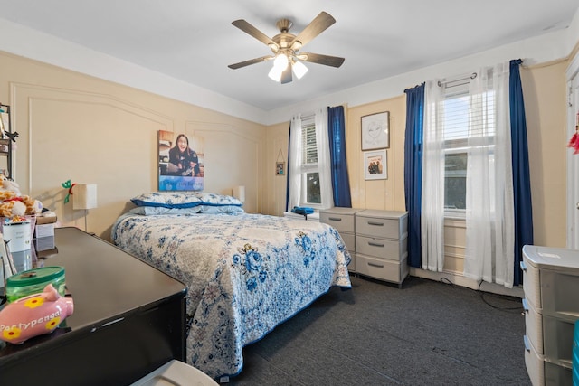 bedroom featuring dark carpet and a ceiling fan