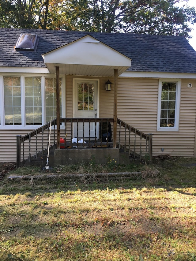 property entrance with roof with shingles