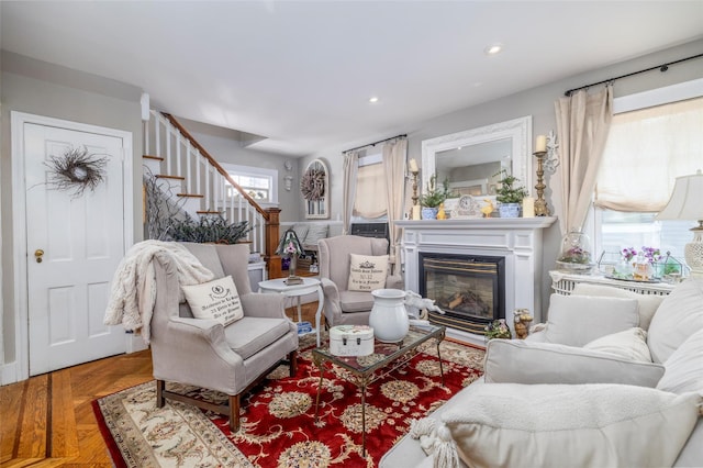 living area featuring stairway, recessed lighting, and a glass covered fireplace