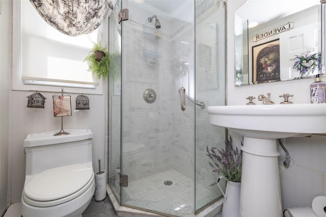 bathroom featuring a shower stall, toilet, and ornamental molding