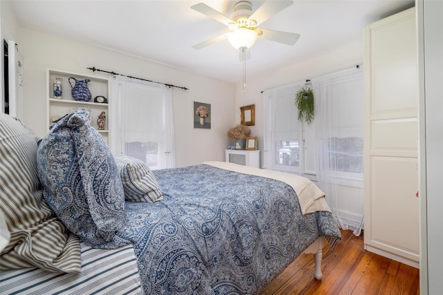 bedroom featuring a barn door, wood finished floors, and ceiling fan