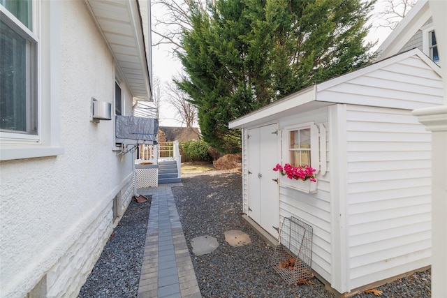 view of side of home featuring an outbuilding and stucco siding