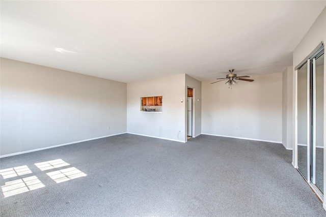 unfurnished room featuring ceiling fan, baseboards, and dark colored carpet