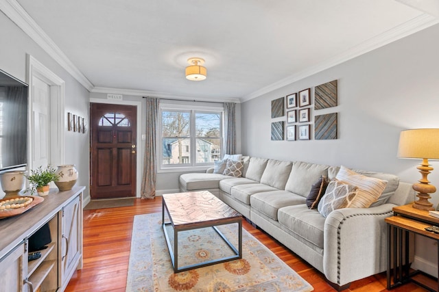 living room featuring baseboards, wood finished floors, and ornamental molding