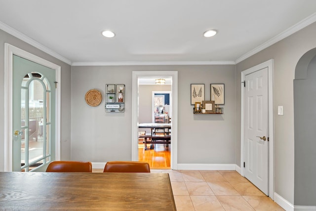 dining room with arched walkways, plenty of natural light, crown molding, and light tile patterned floors