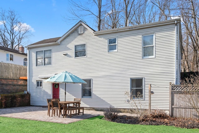 back of property featuring a yard, a patio, and fence