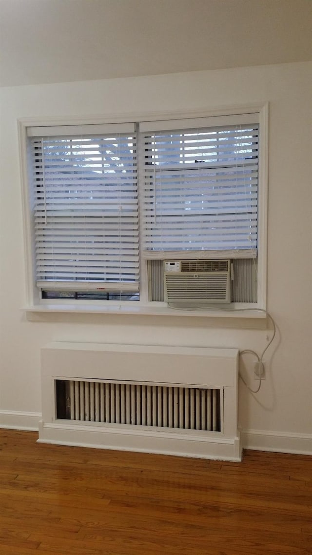 room details with radiator, wood finished floors, and baseboards