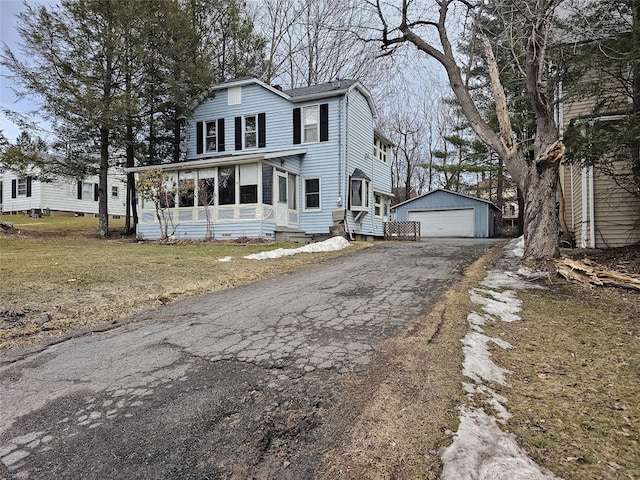 view of front of house featuring an outbuilding, a detached garage, and a front yard