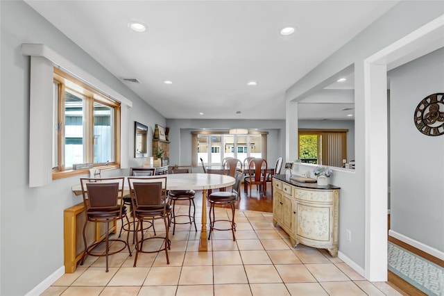 dining space with light tile patterned floors, recessed lighting, visible vents, and baseboards