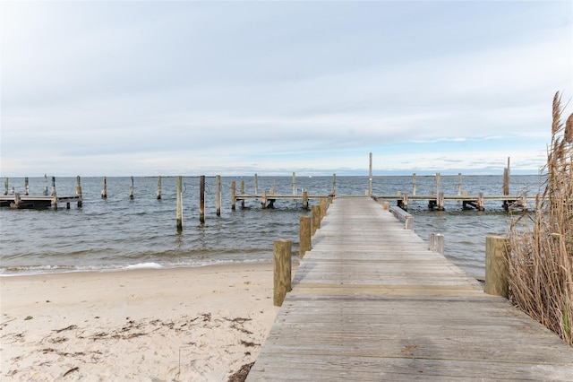 view of dock with a view of the beach and a water view