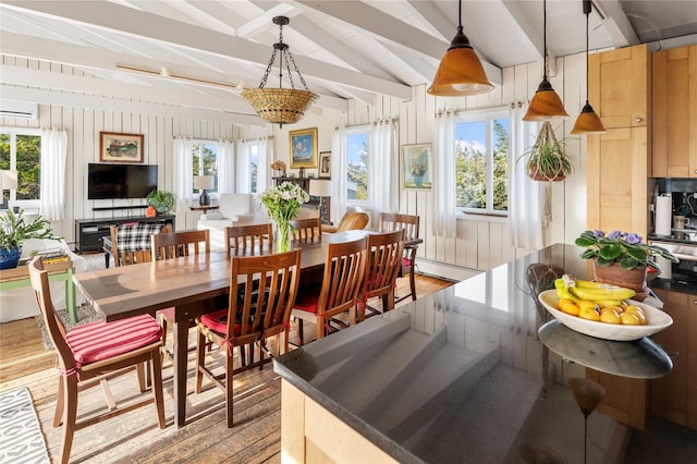 dining area with vaulted ceiling with beams, light wood-style floors, and plenty of natural light