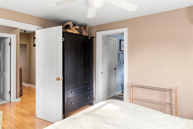 unfurnished bedroom featuring baseboards, light wood finished floors, and ceiling fan