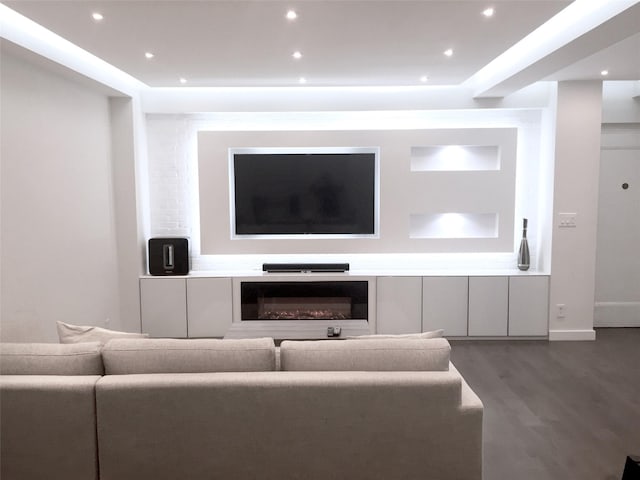 living room featuring a glass covered fireplace, recessed lighting, and wood finished floors