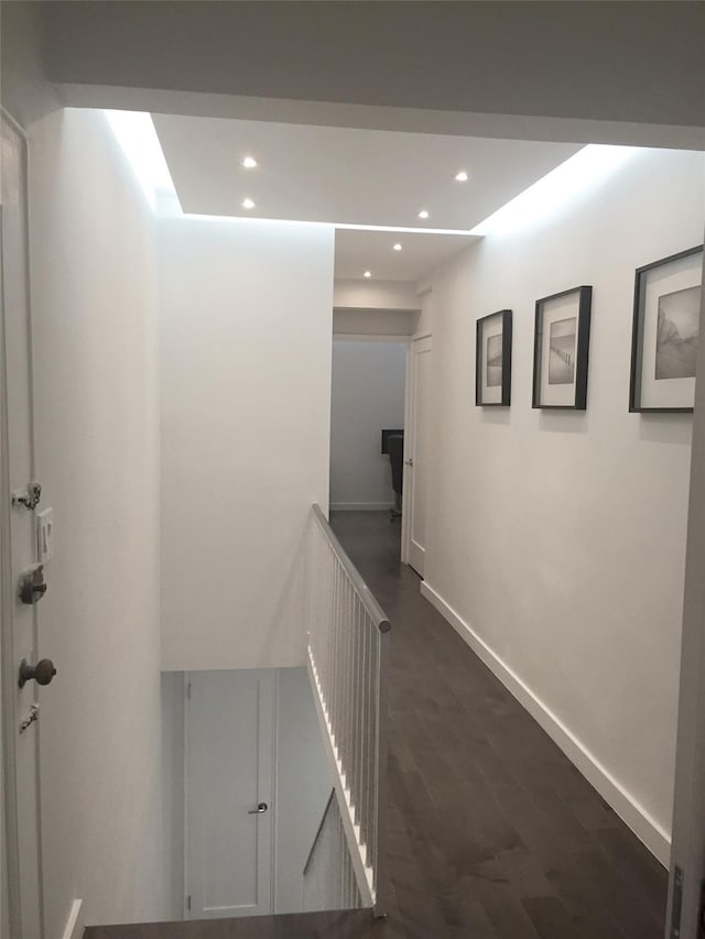 hall with dark wood-type flooring, recessed lighting, an upstairs landing, and baseboards