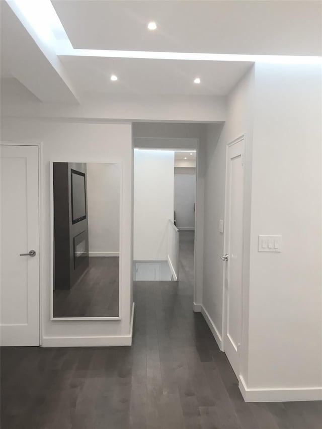 hall featuring recessed lighting, baseboards, and dark wood finished floors