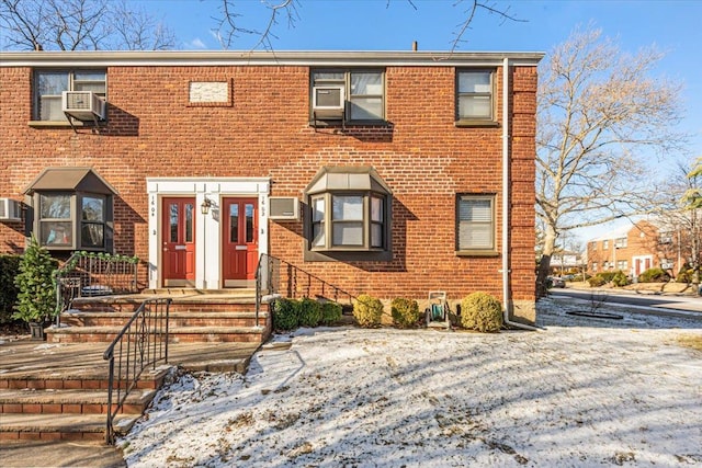 view of front of property featuring cooling unit and brick siding