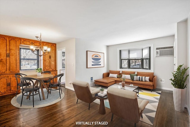 living room with baseboards, dark wood-type flooring, a notable chandelier, and an AC wall unit