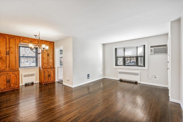 interior space with dark wood finished floors, a wall unit AC, radiator heating unit, and a chandelier