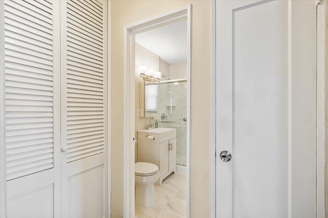 bathroom featuring vanity, a shower stall, a closet, toilet, and marble finish floor