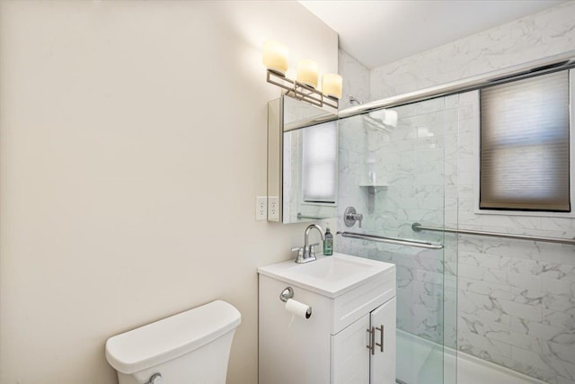 bathroom with vanity, toilet, and a shower stall