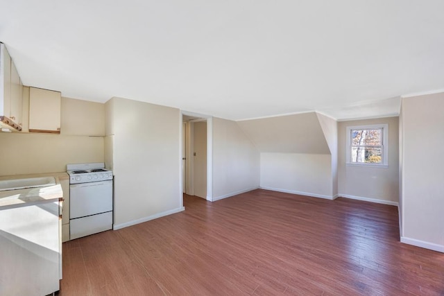 additional living space with vaulted ceiling, light wood-style floors, and baseboards