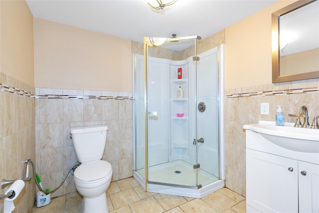 full bath with vanity, a shower stall, tile walls, toilet, and tile patterned floors