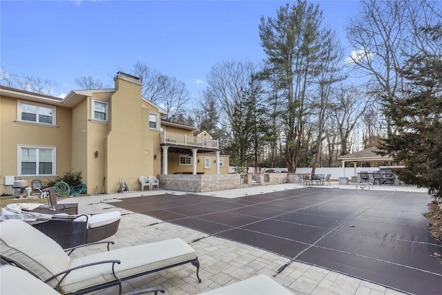 view of patio with outdoor dining area, a balcony, and fence