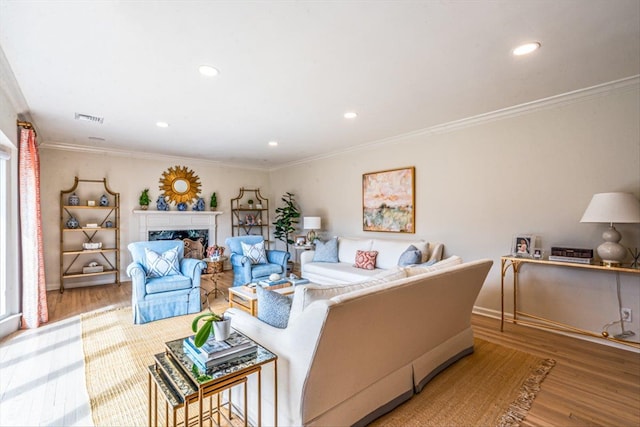 living room featuring crown molding, wood finished floors, and visible vents