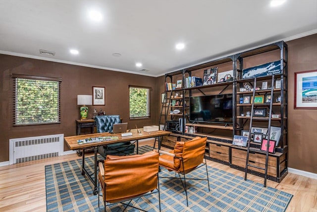 office area featuring radiator, wood finished floors, baseboards, visible vents, and ornamental molding