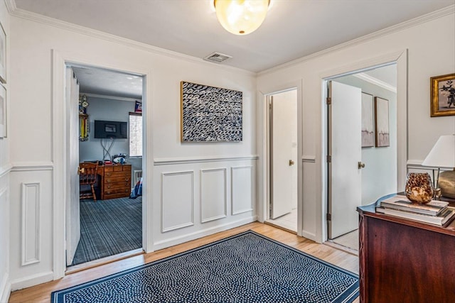 interior space with visible vents, light wood-style floors, and ornamental molding