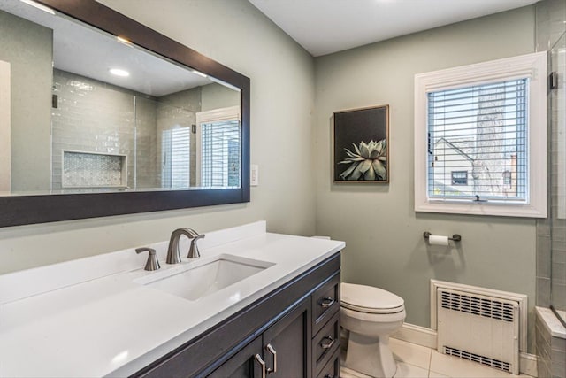bathroom with baseboards, toilet, radiator heating unit, a tile shower, and vanity