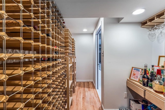 wine room with recessed lighting, light wood-type flooring, and baseboards