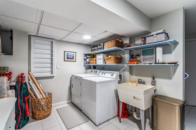 laundry room with light tile patterned floors, baseboards, separate washer and dryer, and laundry area