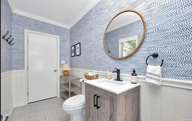 bathroom featuring a wainscoted wall, ornamental molding, and wallpapered walls