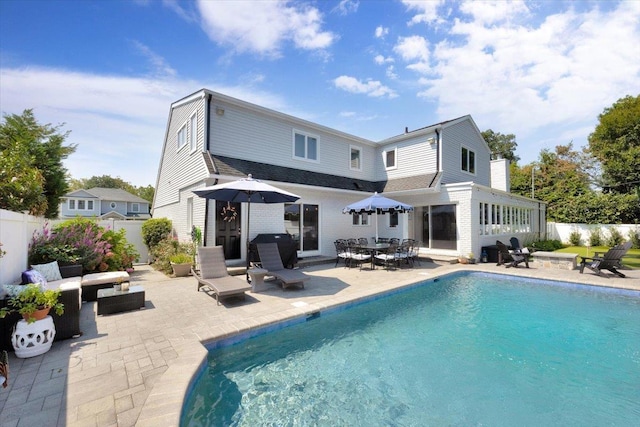 back of property featuring a fenced in pool, fence, and a patio area