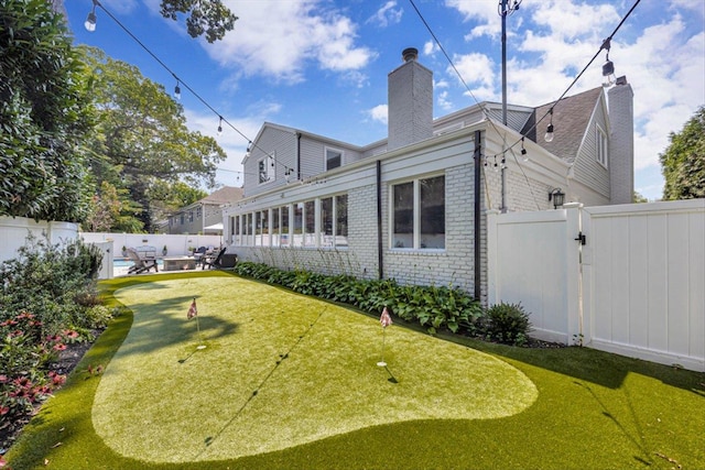 view of yard with a patio area, a fenced backyard, and a gate