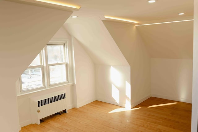 bonus room featuring recessed lighting, lofted ceiling, radiator heating unit, and light wood finished floors