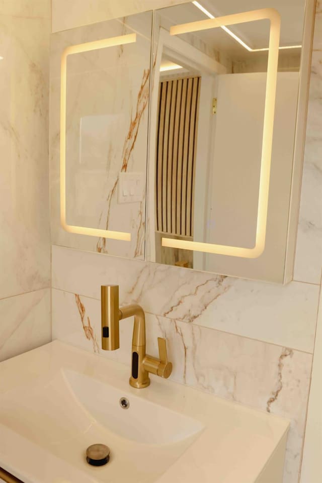 bathroom with tile walls, tasteful backsplash, and a sink