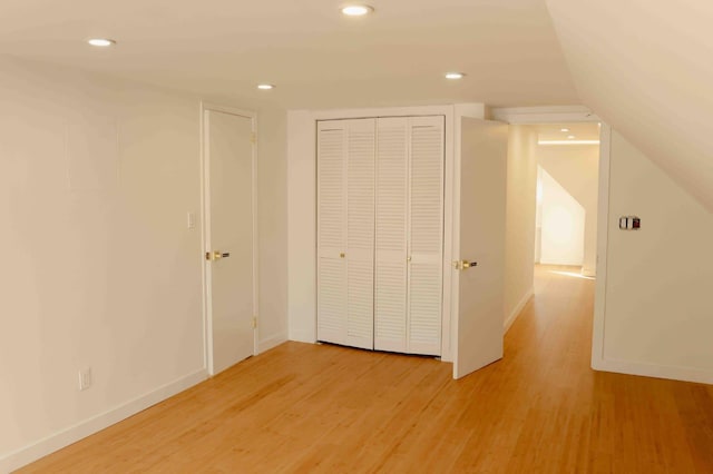 unfurnished bedroom with recessed lighting, a closet, light wood finished floors, and baseboards